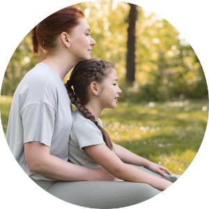Mujer y niña sentados juntos en actitud meditativa